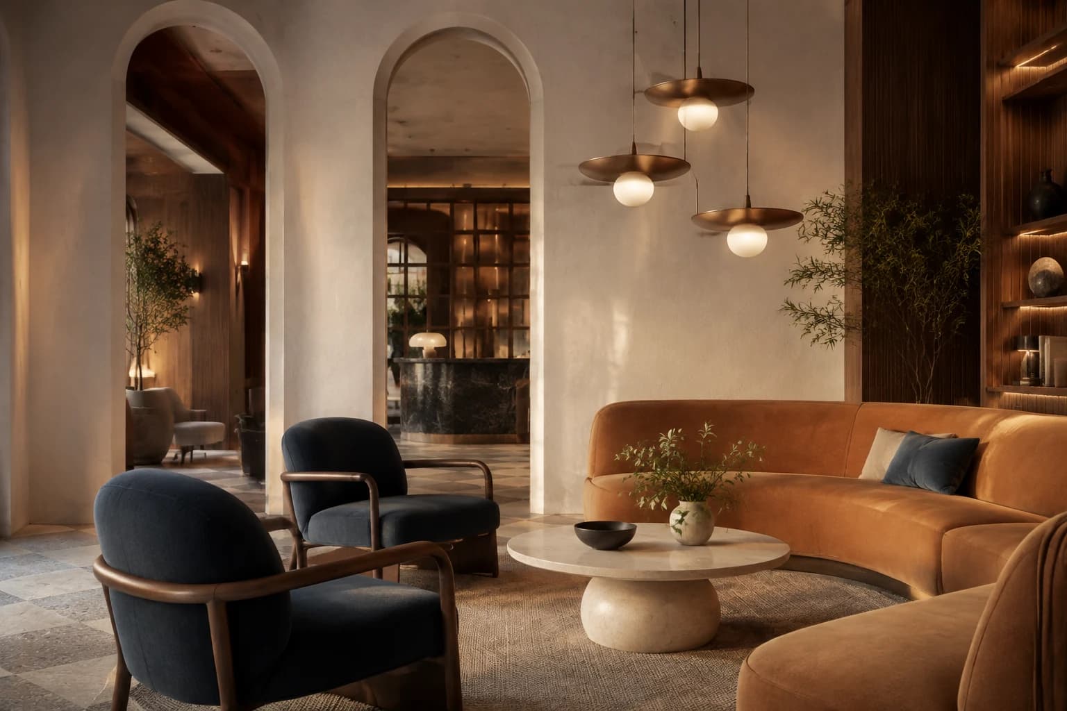 Boutique hotel lounge with sculpted plaster arches, caramel seating, slate blue chairs, and warm bronze pendant lighting.